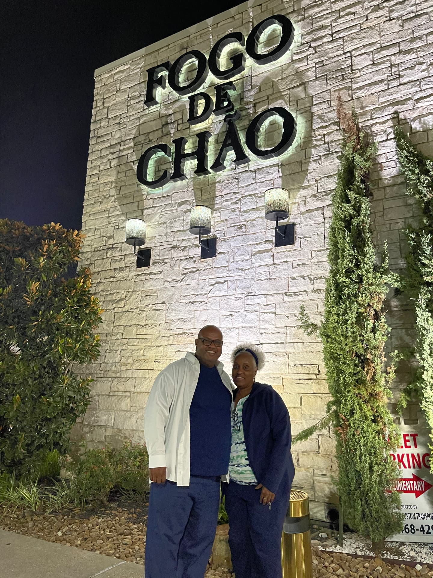 Momma Peggy and family outside a restaurant at night under warm lights.