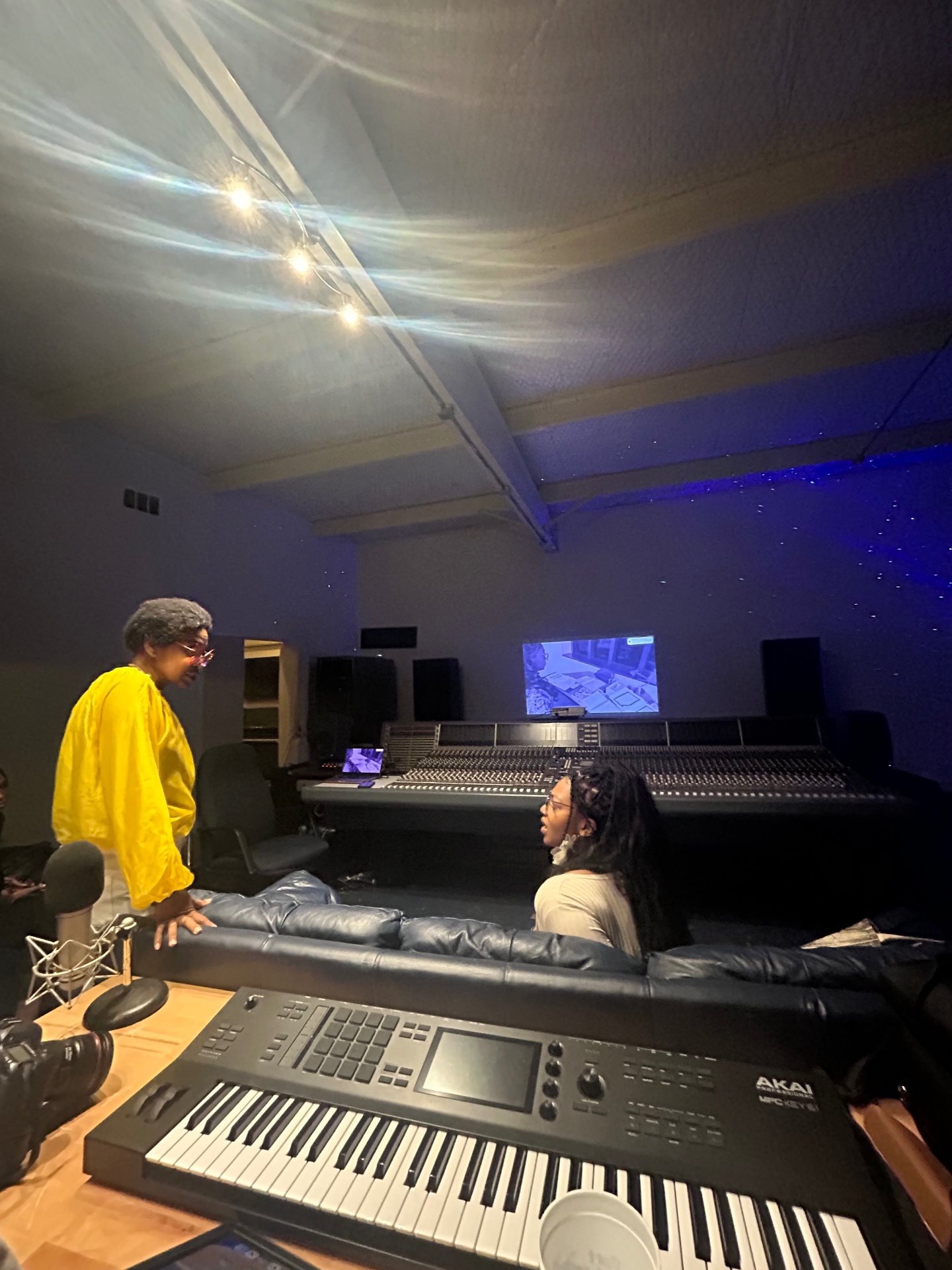 SSL · Star-cloth ceiling — Yellow at the desk. MPC Key 61 up front, SSL behind, the ceiling drifting into stars.