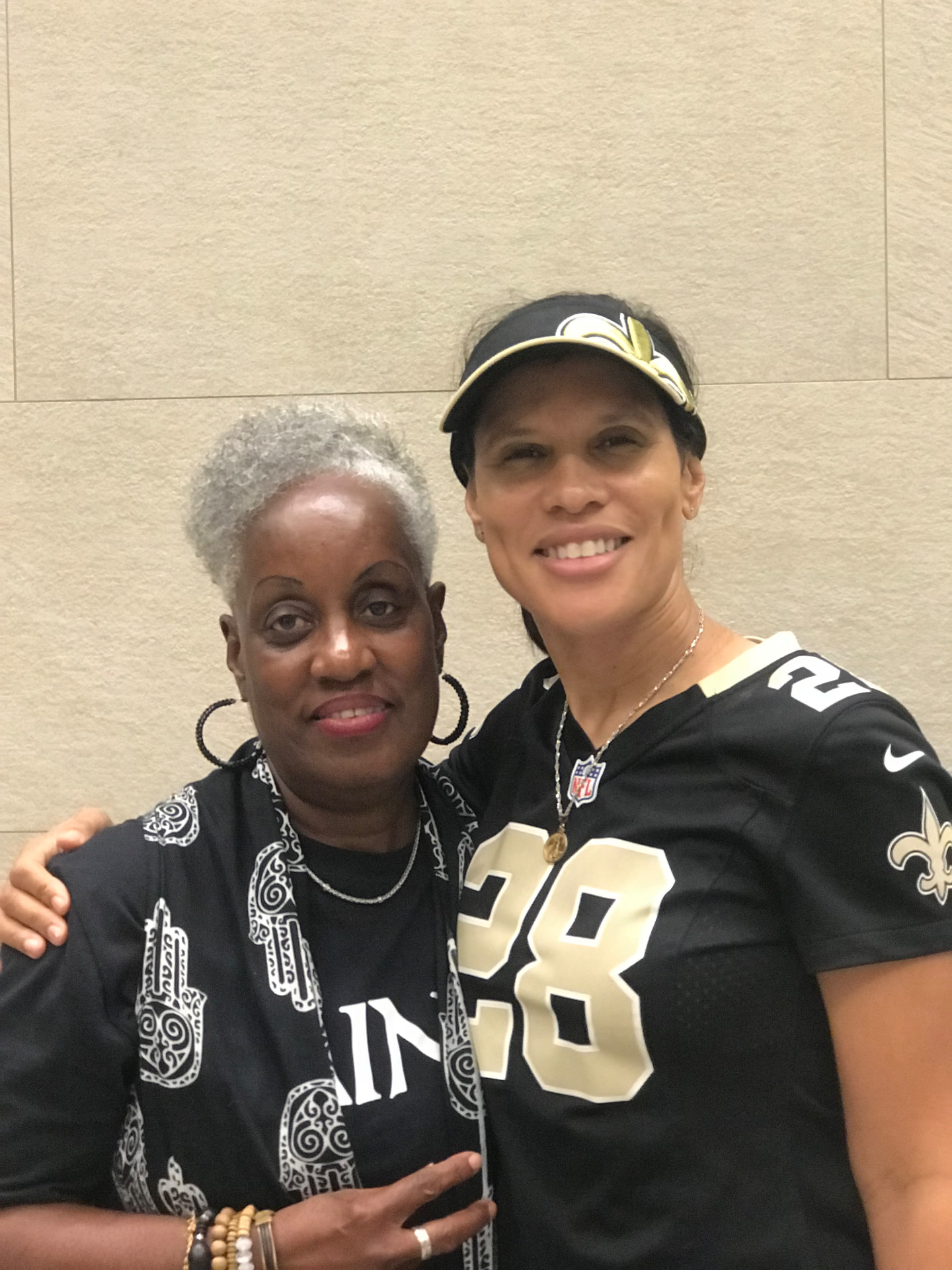 Momma Peggy in Saints black and white with a friend in a number 28 Saints jersey.