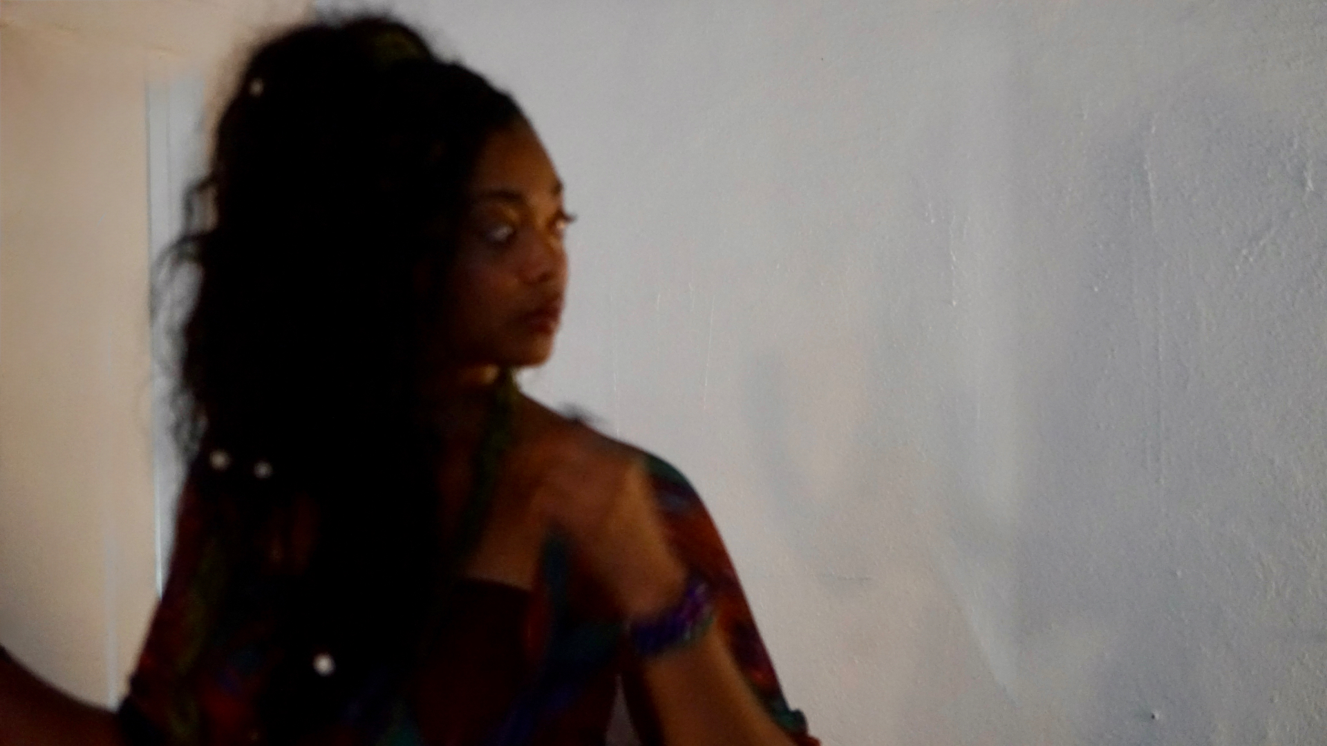 Aaniyah turned away from the microphone against a white booth wall