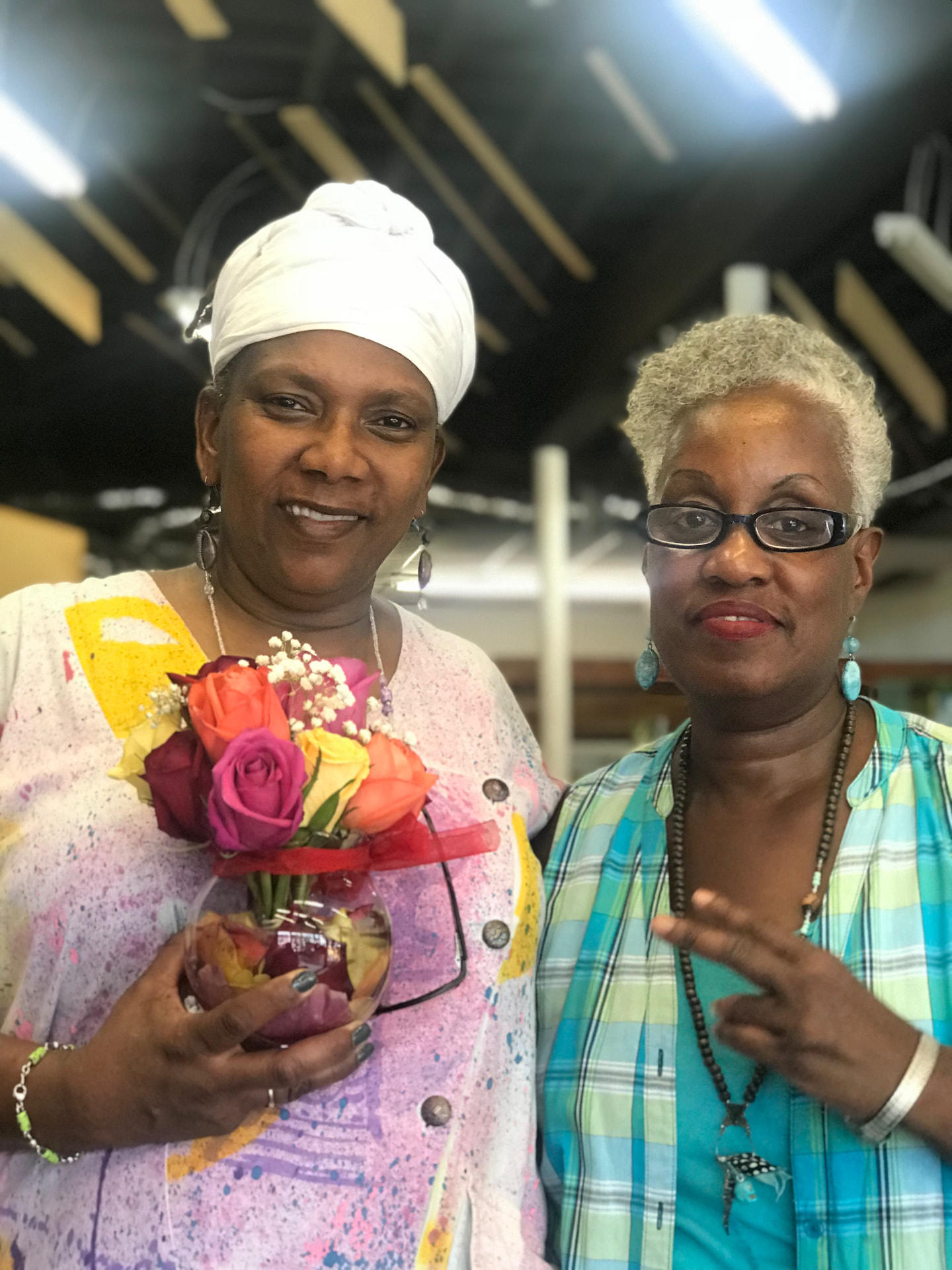 Momma Peggy standing with a friend holding a bowl of roses.